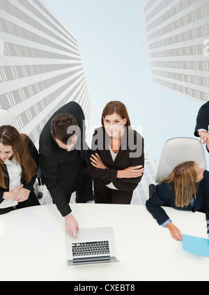 Femme mature rencontre avec des collègues, des gratte-ciel en surimpression sur l'arrière-plan Banque D'Images