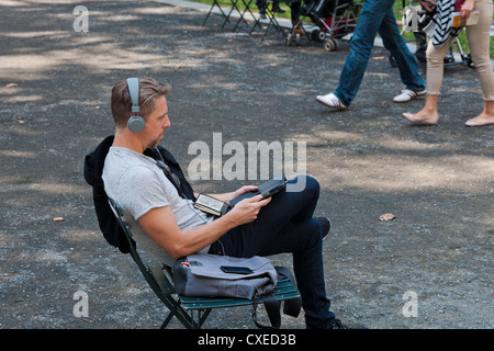 Un parkgoer utilise son iPad pour écouter de la musique en Bryant Park à New York le Mardi, Juillet 24, 2012 (© Richard B. Levine) Banque D'Images