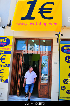 Homme marchant d'un 1Euro shop( comme un UK £1 shop ) à Rethymnon Crète Banque D'Images