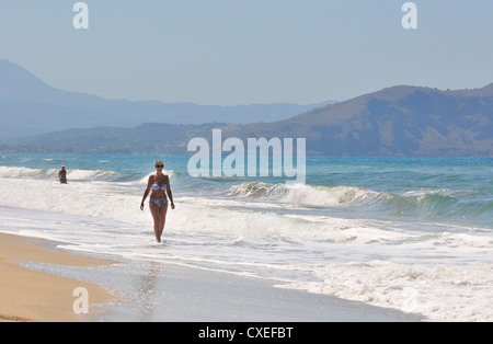 Dame marchant dans le surf le long de la plage Paralia Kouma - à l'ouest de Réthymnon , Crète, Iles grecques, UE Banque D'Images