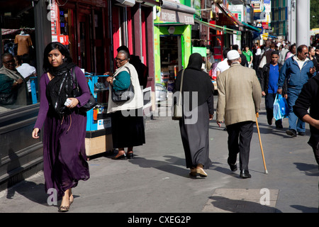 Les gens de différentes origines ethniques autour du marché sur Whitechapel High Street à l'Est de Londres. Banque D'Images