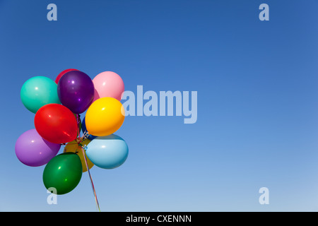 Un bouquet de ballons de couleur vive en face d'un ciel bleu vif with copy space Banque D'Images