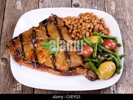 T-bone steak avec le porc et les haricots et les légumes. Banque D'Images