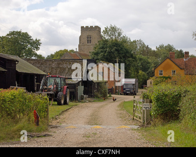 Une scène d'un pays anglais, basse-cour avec dépendances, tracteur, poules/poulets et un clocher d'église. Banque D'Images