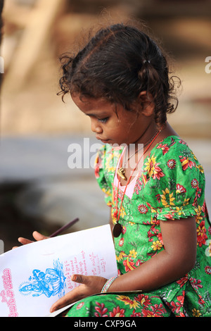 Little Indian School girl playing et dessin au crayon l'Andhra Pradesh en Inde du Sud Banque D'Images