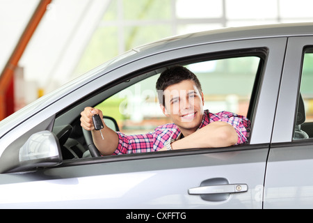 Un homme assis dans sa voiture, et la tenue d'une clé de voiture Banque D'Images