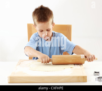 Petit garçon d'aider dans la cuisine - Pâte de roulement pour les biscuits de Noël Banque D'Images