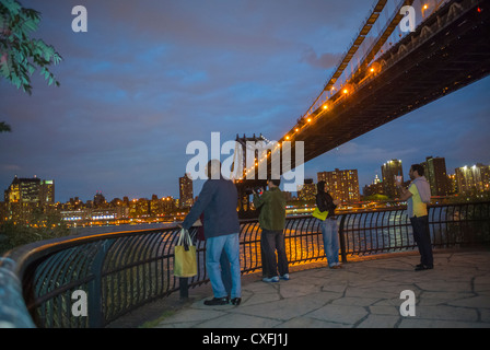 New York City, NY, États-Unis, personnes de groupe, touristes, visite, Manhattan Skyline, de DUMBO Brooklyn Bridge Park, East River, Manhattan Bridge, Scenic View at Dusk Night City atmosphère aux États-Unis Banque D'Images