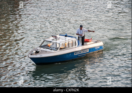 Un membre de la polizia locale (police locale) dirigeant le trafic maritime sur le Grand Canal à Venise, Italie Banque D'Images