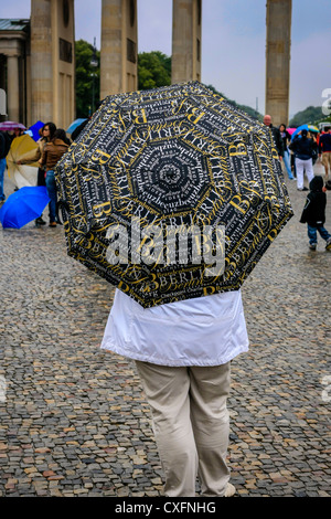 Femme debout avec un souvenir parapluie Berlin près de la porte de Brandebourg Banque D'Images