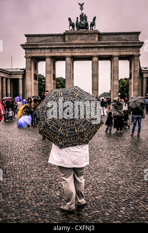 Femme debout avec un souvenir parapluie Berlin près de la porte de Brandebourg Banque D'Images