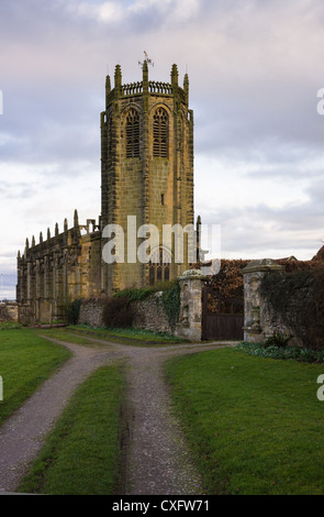 Soleil illumine la tour octogonale de l'église Saint-Michel d'tel qu'il se couche sur le Coxwold North Yorkshire Moors. Banque D'Images