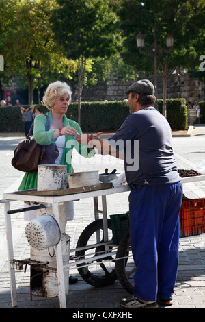 Achat femme sex châtaignes grillées à un vendeur de rue dans le centre historique de Séville Espagne Espagnol Banque D'Images