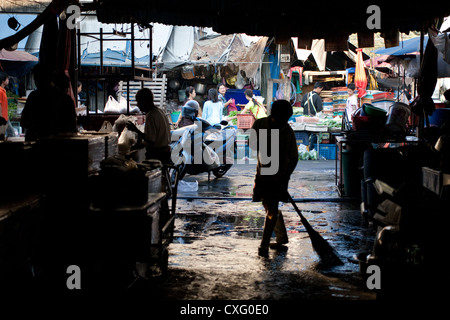 Vendeur marché balaie après une journée bien remplie dans le marché Bangkok Thaïlande Banque D'Images