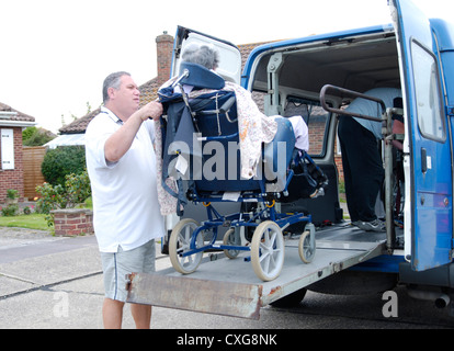 Vieille Femme dans un fauteuil roulant sur la rampe d'une plate-forme de levage spécialisée véhicule adapté pour le transport des personnes à mobilité réduite service volontaire Banque D'Images