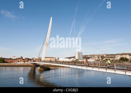 Les cyclistes de traverser la rivière tawe sur le pont voile de Swansea, qui fait partie de la nouvelle SA1 le développement dans la Baie de Swansea, Pays de Galles. Banque D'Images