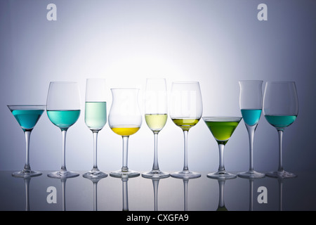 Des verres à vin de différentes tailles et formes rempli de cocktails colorés Banque D'Images