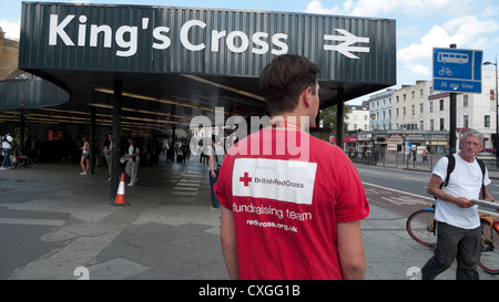 La Croix Rouge britannique chugger sollicite des dons en face de la gare de King's Cross de Londres Angleterre Royaume-uni signe KATHY DEWITT Banque D'Images