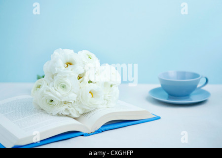 Bouquet sur le livre et tasse de thé Banque D'Images