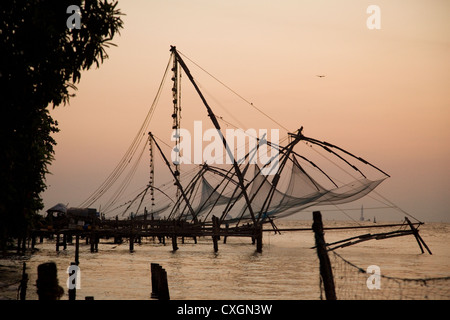 Filets de pêche chinois traditionnel au coucher du soleil, Cochin, Inde. Banque D'Images