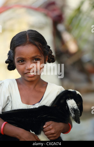 L'école indienne fille jouant avec son animal goat Andhra Pradesh Inde du Sud Banque D'Images