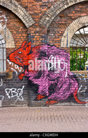 Les graffitis urbains d'un rat géant par les artistes de rue Broken Fingaz Crew peint sur arches en briques est de Londres Angleterre Europe Banque D'Images