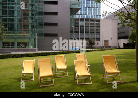 Chaises longues jaune sur l'herbe en dehors de la nouvelle cour des bureaux dans le centre-ville de Manchester Banque D'Images