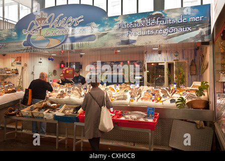 Les clients et les fournisseurs à Les Viviers du Noirmoutier, un poissonnier'sstand au Marché Couvert Saint-Quentin dans le centre de Paris. Banque D'Images