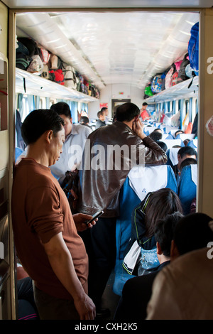 Debout dans une deuxième classe, siège de transport d'un train chinois. Banque D'Images