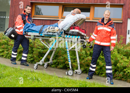 Les ambulanciers avec patient sur civière d'urgence l'aide d'ambulances femme homme Banque D'Images