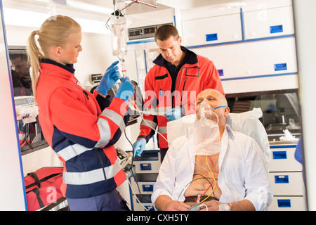 Paramedic putting oxygen mask on patient ambulance urgence malades Banque D'Images