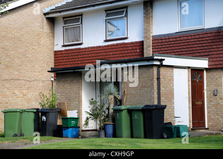 Face de la maison avec de grandes quantité de poubelles et bacs de recyclage dans le jardin avant l'Angleterre Surrey Banque D'Images