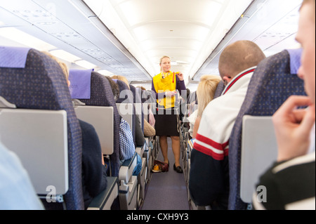 L'équipage de cabine de Monarch Airlines est en train de faire une démonstration de sécurité avant le vol, en Angleterre, au Royaume-Uni Banque D'Images