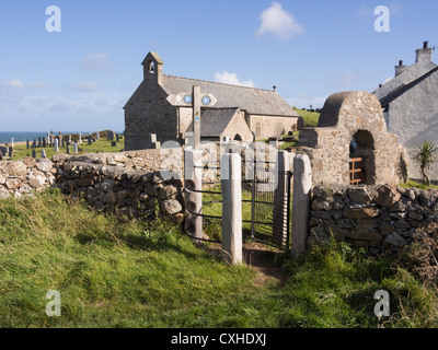 Isle of Anglesey côte panneau routier et les baisers gate par de minuscules 5e siècle, l'église de St Patrick. Llanbadrig Cemaes Anglesey Pays de Galles UK Banque D'Images