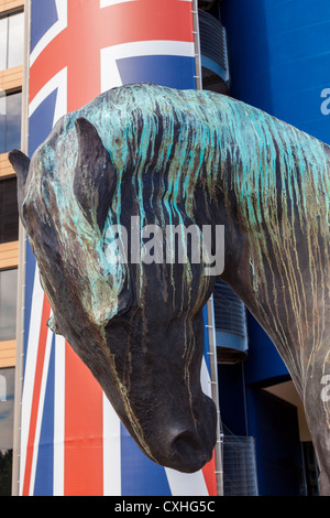 Union Jack britannique drapeaux et sculpture d'une tête de cheval à l'Ascot Racecourse entrée Tribune dans la lumière du soleil glorieux. Banque D'Images