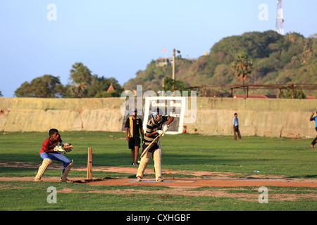 Les jeunes hommes jouant un jeu de cricket pratique à Trincomalee, Sri Lanka. Banque D'Images