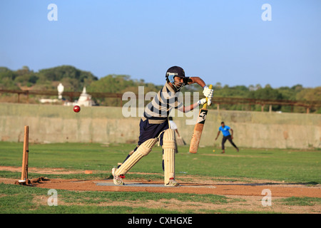 Les jeunes hommes jouant un jeu de cricket pratique à Trincomalee, Sri Lanka. Banque D'Images