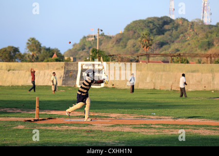 Les jeunes hommes jouant un jeu de cricket pratique à Trincomalee, Sri Lanka. Banque D'Images