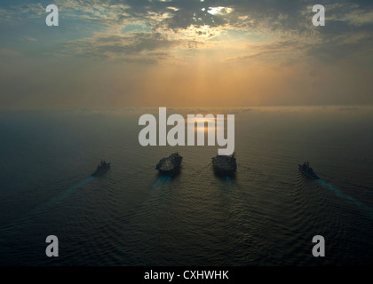 Porte-avions USS Enterprise porte-avions USS Dwight D. Eisenhower, croiseurs lance-missiles USS Vicksburg et USS Hue en cours ensemble vers le lever du soleil en formation le 27 septembre 2012 dans la mer d'Oman. Banque D'Images