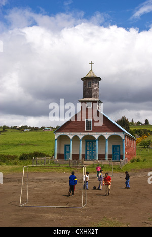 Elk198-3897 le Chili, l'Ile de Chiloé, Isla Lemuy, Iglesia de Putchitco l'église, les enfants jouant au football Banque D'Images