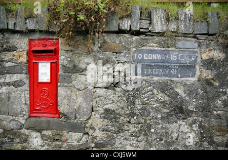 Petite boite aux lettres et signes de la direction de la pierre à Conway et Wrexham, à Betws-Y-coed, Conwy, au nord du Pays de Galles. Banque D'Images