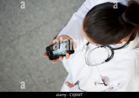 Femme médecin à la recherche de x-ray sur un smartphone Banque D'Images