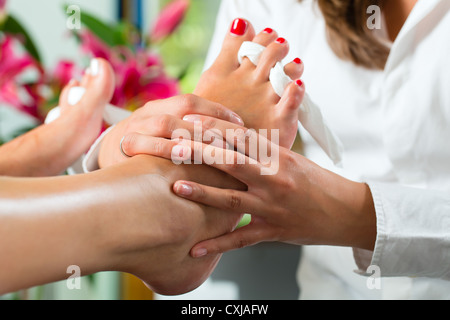 Woman receiving pédicure dans un Spa de jour, les ongles des pieds et elle est polie obtenir obtenir un massage des pieds Banque D'Images