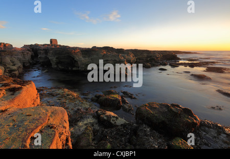 Lever du soleil à Seahouses sur la côte de Northumberland. Grès et the Old Powder House. Banque D'Images