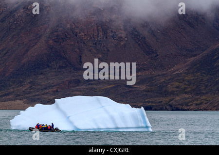 Zodiac avec les touristes côtes par petit iceberg au Nunavut, Canada. L'été, de l'Arctique. Banque D'Images