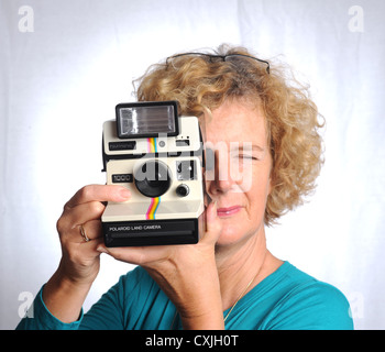 Femme féminine avec une vieille caméra Polaroid Land 1000 UK Banque D'Images