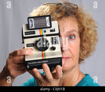 Femme féminine avec une vieille caméra Polaroid Land 1000 UK Banque D'Images