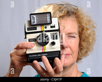 Femme féminine avec une vieille caméra Polaroid Land 1000 UK Banque D'Images