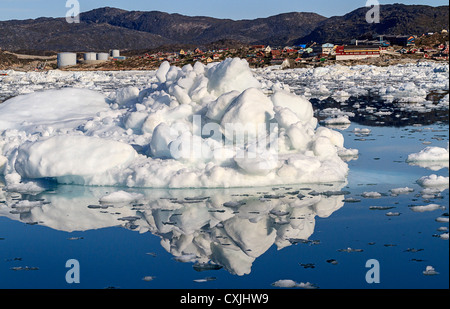 Bâtiments colorés de Ilulissat s'asseoir sur le bord de la ville de glace du port et étouffé se reflètent dans l'eau entre la glace bits. Banque D'Images