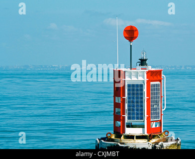 Bouée maritime lumineux au milieu de l'océan, entouré d'eau bleu et bleu ciel. Banque D'Images